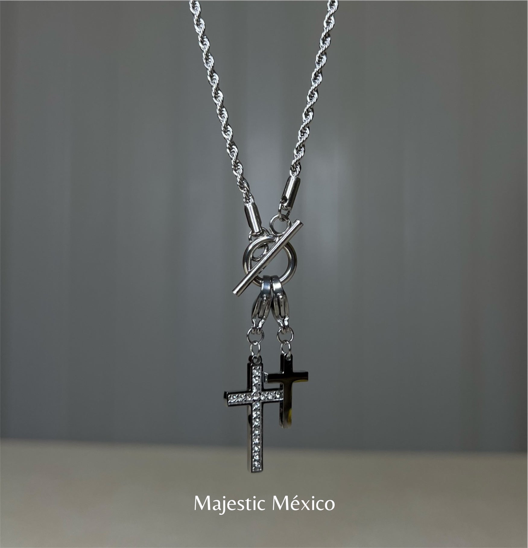 Collar de acero inoxidable plateado con dos cruces, una con cristales y broche tipo T, joyería espiritual Majestic México